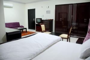 a bedroom with a bed and a couch and a tv at Paradise Inn Hotel (Tabasum Group) in Ajman 