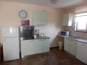 a kitchen with white appliances and a clock on the wall at Apartment Vera in Zadar