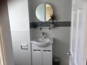 a white bathroom with a sink and a mirror at Modern Chic Loft Apartment in Birmingham
