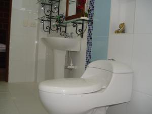 uma casa de banho branca com um WC e um lavatório em Casa Hotel Portón Campestre em Jardin