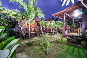 a house with a bunch of palm trees in the yard at Lembongan Bagus Villa in Nusa Lembongan