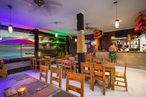a restaurant with wooden tables and chairs and a bar at Linda Beach Hotel in Nusa Lembongan