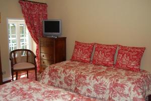 a bedroom with a bed and a television on a dresser at Hostellerie de la Motte jean in Saint-Coulomb