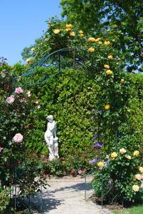 a statue sitting in a garden with flowers at Hostellerie de la Motte jean in Saint-Coulomb