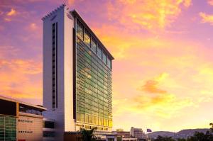 un edificio alto con un tramonto sullo sfondo di The Stanley Hotel & Suites a Port Moresby