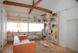 a living room with a couch and chairs and bookshelves at INTRO Tamagawa in Kanazawa