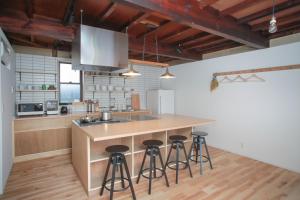 a kitchen with a island with bar stools at INTRO Tamagawa in Kanazawa