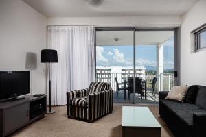 ein Wohnzimmer mit einem Sofa und einem TV in der Unterkunft Central Kensington Apartments in Townsville