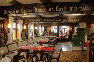 a restaurant with tables and chairs and a sign at Hotel Zum Bürgergarten in Stolberg