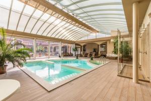 an indoor swimming pool with a glass ceiling at Vinum Hotel in Kiskőrös