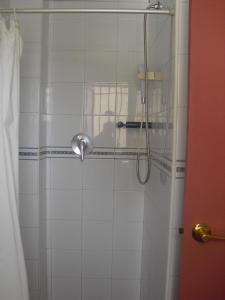 y baño con ducha y puerta de cristal. en Pensión Juan Pedro, en Roquetas de Mar
