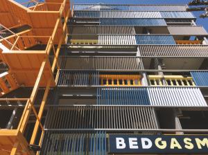 清邁的住宿－BEDGASM Hotel x Cafe Nimman，一座黄色和蓝色金属楼梯的建筑