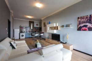 a living room with a white couch and a kitchen at Casa do Louro in Arco da Calheta