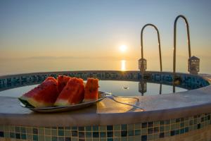 a plate of watermelon on a plate in a bath tub at Villa Evita in Mesongi