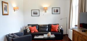 a living room with a black couch and a table at Le Baron Suites & Apartments in Stavelot