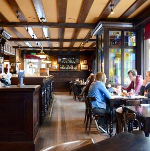 een groep mensen die aan tafel zitten in een restaurant bij Le Baron Apartments in Stavelot