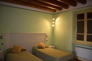 a bedroom with two beds and a window at Agriturismo Cà Del Lupo in Palazzolo sullʼOglio
