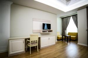 a living room with a table and a tv at Hotel Vila Imperial in Elbasan
