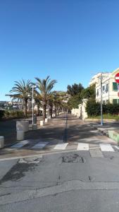 una calle vacía con palmeras y un edificio en Casa Marina en Arma di Taggia