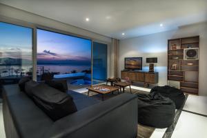 a living room with a couch and a large window at Sunset Sea View Apartment in Bang Rak Beach