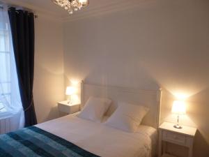 ein Schlafzimmer mit einem weißen Bett mit zwei Lampen in der Unterkunft Résidence du Cygne - Swan Residence - Paris centre in Paris
