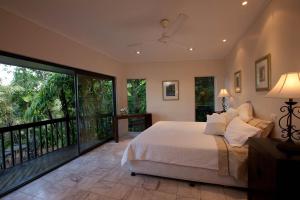 a bedroom with a large bed and a balcony at Sapphire Ridge in Palm Cove