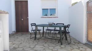 a table and chairs in a room with a door at Alojamiento Rural El Abuelo in Conil de la Frontera