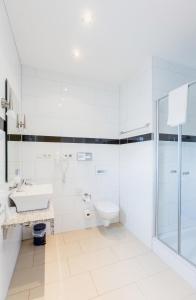 a white bathroom with a sink and a toilet at Business Pension Gasper in Raunheim