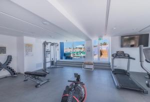 a gym with several tread machines and a bike in a room at Hotel LIVVO Los Calderones - Adults recommended in Maspalomas