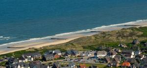 an aerial view of a beach with houses and the ocean at Hotel Strandhörn in Wenningstedt