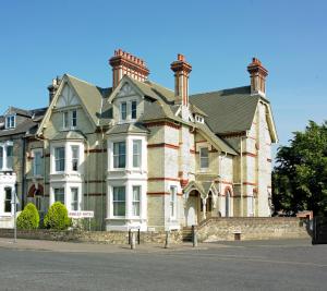 a large brick house with two chimneys on top at Ashley Hotel in Cambridge