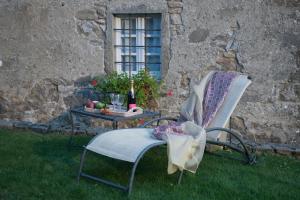 a chair and a table with a bottle of wine at SASSO AL MELO - Apartments in Cutigliano