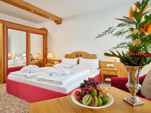 ein Hotelzimmer mit einem Bett und einer Obstschale auf dem Tisch in der Unterkunft Hotel Maximilian in Bad Griesbach