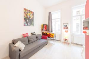 sala de estar con sofá gris y algunas ventanas en happy home FOX, en Budapest