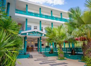 a building with palm trees in front of it at Sai Gon Phong Nha Hotel in Phong Nha