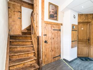 a hallway with a wooden door and stairs at Gîtes Strengbach in Ribeauvillé