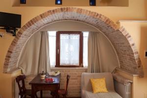 a living room with a brick archway and a table at Villa Fiorita in Grottammare