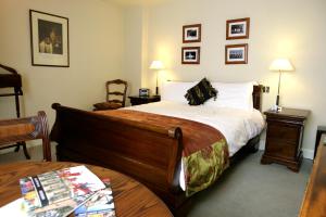 a hotel room with a large bed and a table at The Old Vine in Winchester
