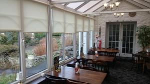 a restaurant with tables and chairs and large windows at The Silverdale Hotel in Silverdale