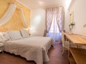 a bedroom with a bed and a desk and a window at Hotel Marina in Monterosso al Mare