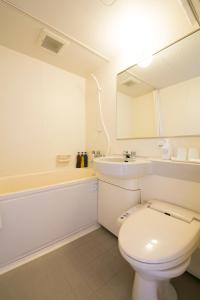 a bathroom with a toilet and a tub and a sink at Hotel nanvan Yaizu in Yaizu