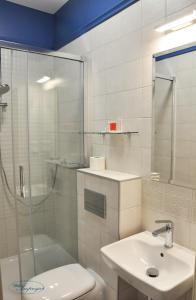 uma casa de banho com um chuveiro, um WC e um lavatório. em Willa Impresja Hotel i Restauracja em Pabianice