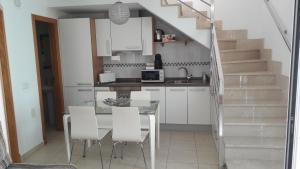 a kitchen and dining room with a table and chairs at Duplex Atlan II in Caleta De Fuste