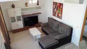 a living room with a couch and a television at Duplex Atlan II in Caleta De Fuste