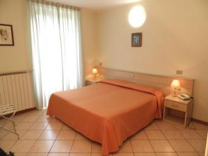 a bedroom with a bed with an orange blanket at Casa Vacanze Touring in Verbania