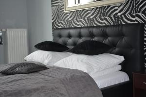 a bedroom with a bed with black and white pillows at Angel City MARCO in Krakow