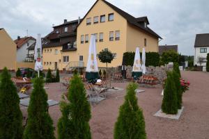 a courtyard with chairs and umbrellas in front of a building at Hotel Sonnenhof in Obersuhl