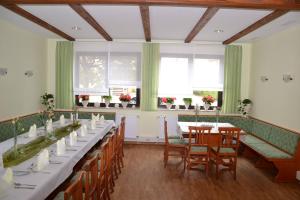 una sala da pranzo con tavoli, sedie e finestre di Hotel Sonnenhof a Obersuhl