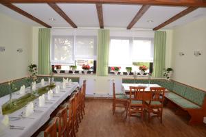 un comedor con mesas, sillas y ventanas en Hotel Sonnenhof, en Obersuhl