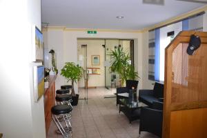 a waiting room with chairs and a row of stools at Hotel Sonnenhof in Obersuhl